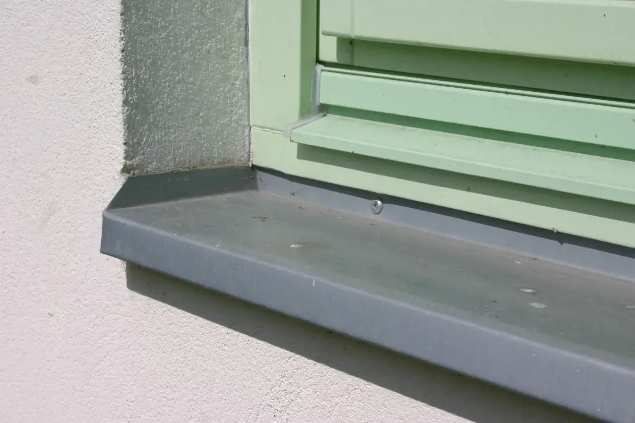 Szary parapet zewnętrzny wystaje ok. 5 cm od ściany, idealnie odprowadzając wodę.