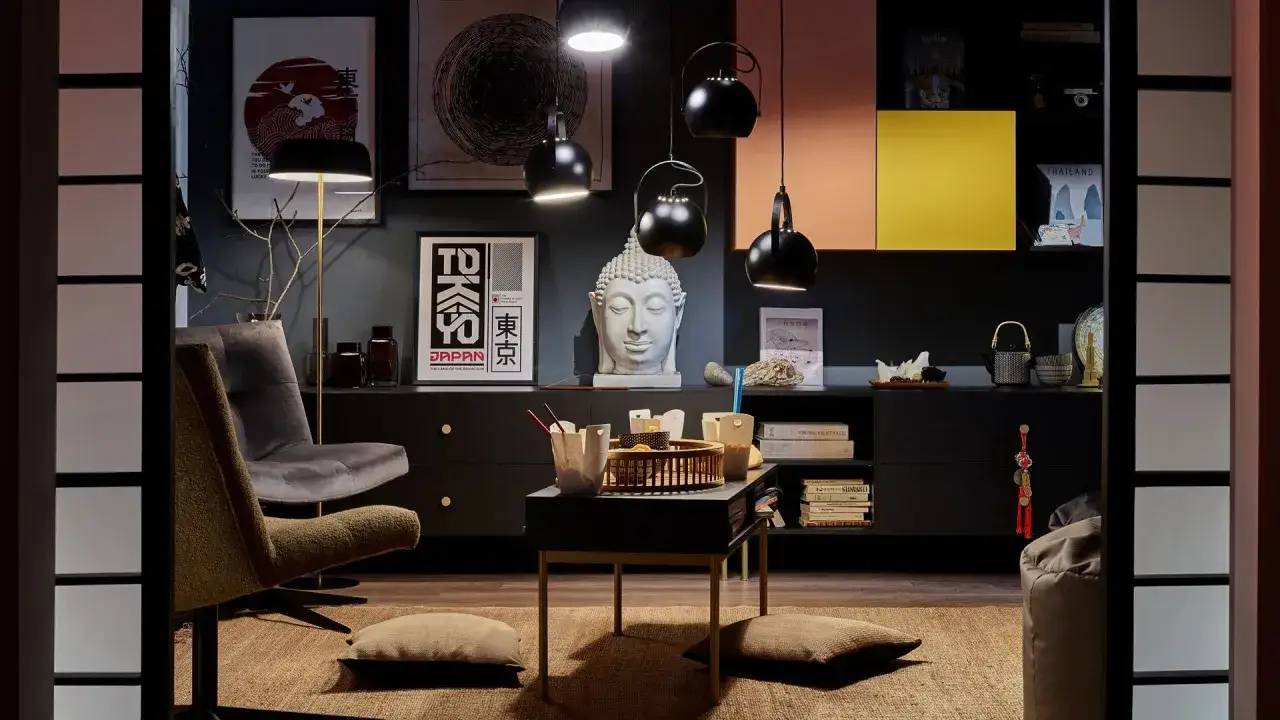 Nowoczesny salon w stylu new eklektyzm. Wygodne fotele, stolik z azjatyckimi akcentami, rzeźba Buddy i grafiki z motywami Japonii.
